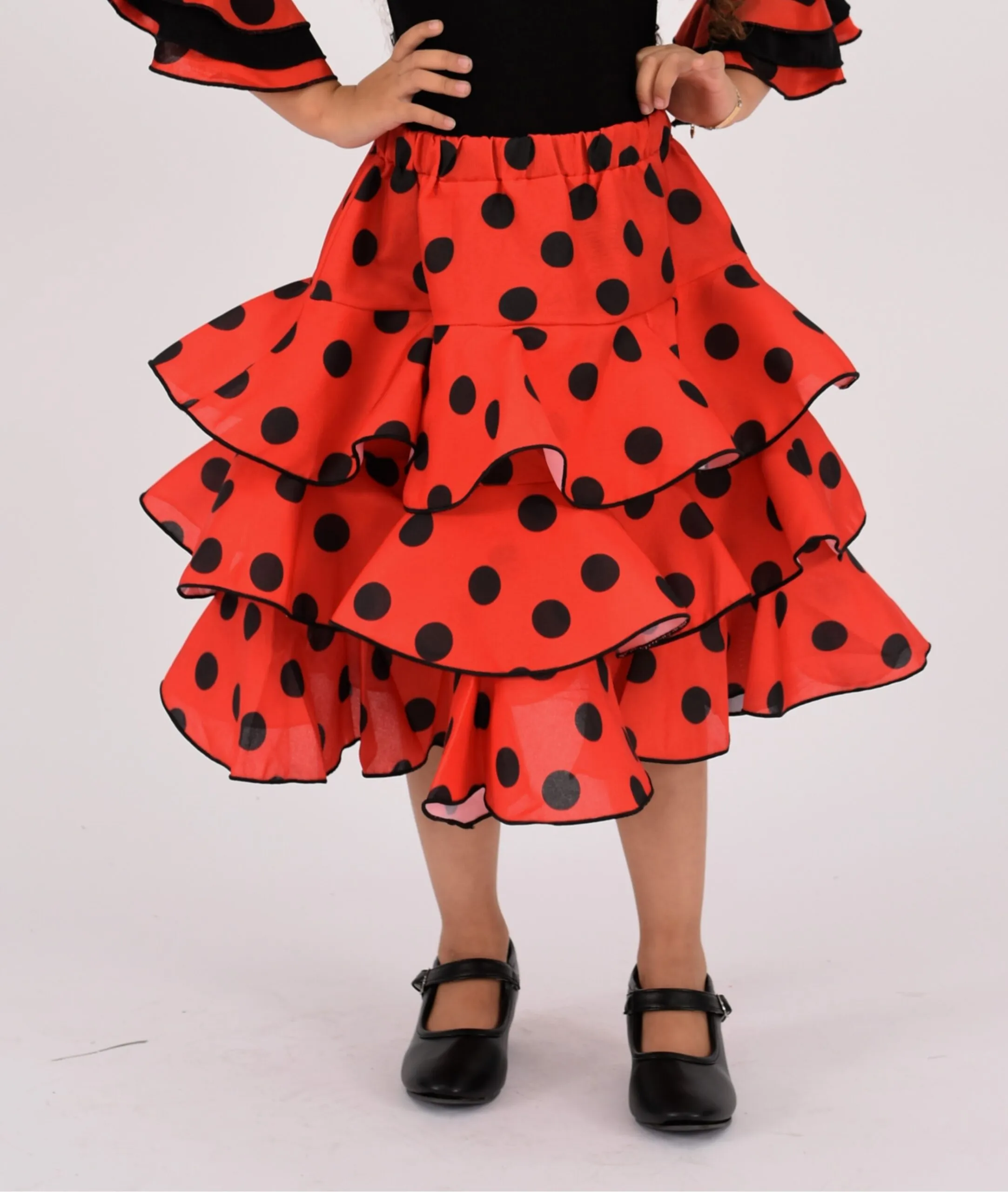 Falda Flamenca para Niña con Diseño de tres volantes rojos con topos negros.